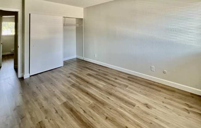 the living room of an empty apartment with wood flooring