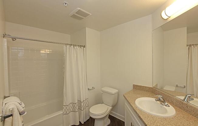 a white sink sitting under a mirror