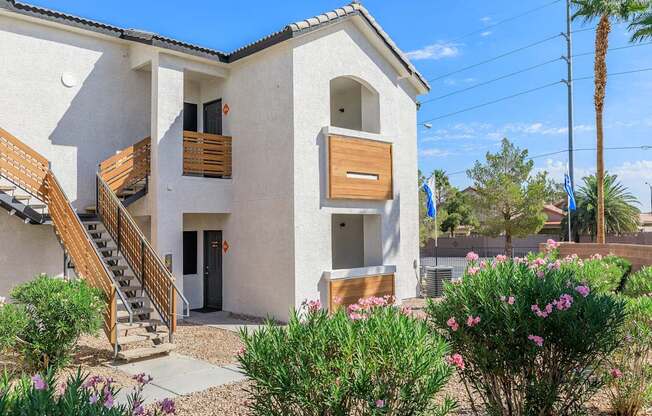 A white house with a wooden staircase and a brown door.