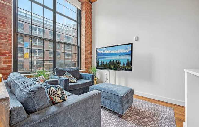 a living room with a large window and a couch and a chair