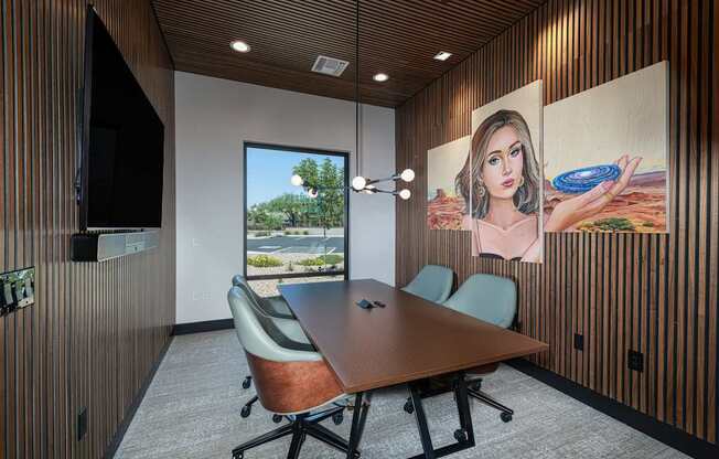 A conference room with a large table and chairs, a television, and a large painting on the wall.