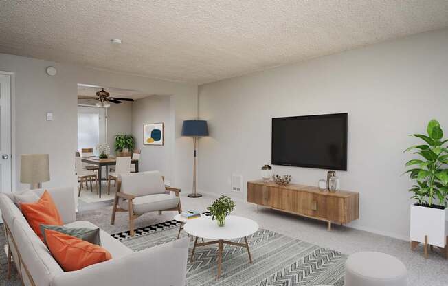 A living room with a white couch, a coffee table, and a television.