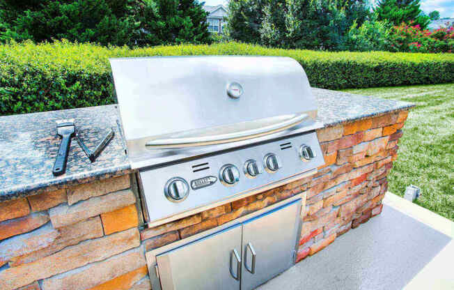 a BBQ grill station outdoor kitchen at Seasons at Umstead apartments in Raleigh