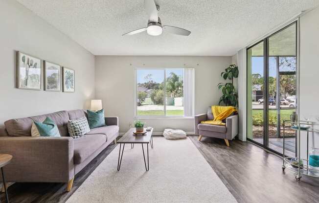 A living room with a grey couch, a coffee table, and a yellow throw pillow.