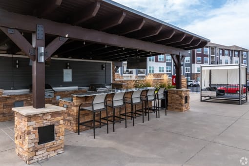 a patio with a bar and a building in the background