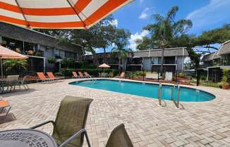 a swimming pool with chairs and an umbrella at a hotel