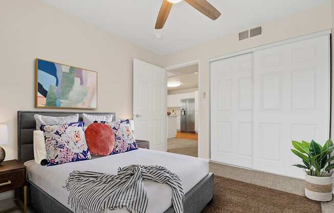 a bedroom with white walls and a ceiling fan