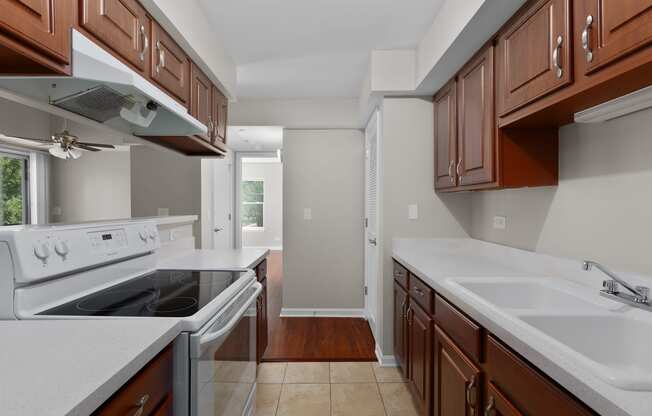 a kitchen with wood cabinets and white counter tops and a stove top oven