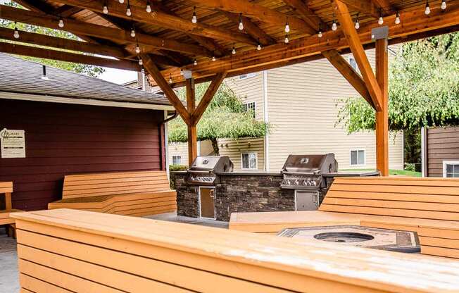 A wooden picnic table under a wooden pergola.