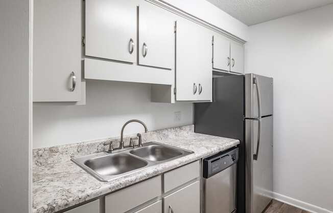 a kitchen with white cabinets and granite countertops