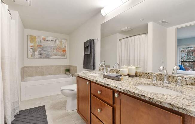 A bathroom with a white tub, sink, and toilet.