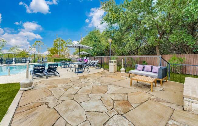 the backyard has a pool and patio with furniture and chairs