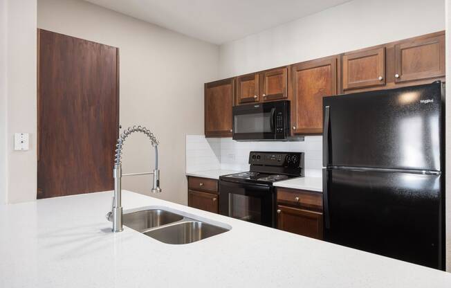 a kitchen with black appliances and white counter tops