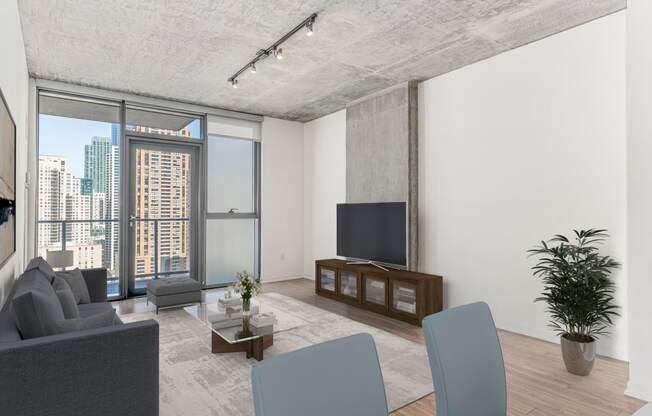 a living room with a gray couch and a tv at One 333, Chicago, Illinois