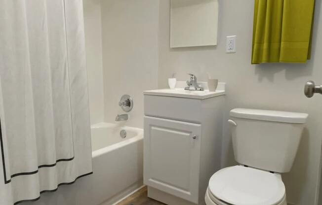 A white toilet sits next to a white sink in a bathroom.