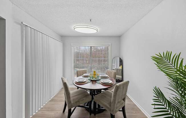 A dining room with a table set for four.