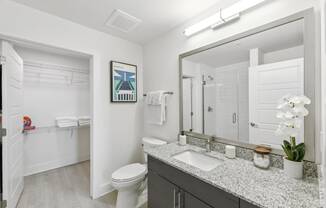 a bathroom with a large mirror and a toilet and a sink  at Link Apartments® H Street, Washington, 20002