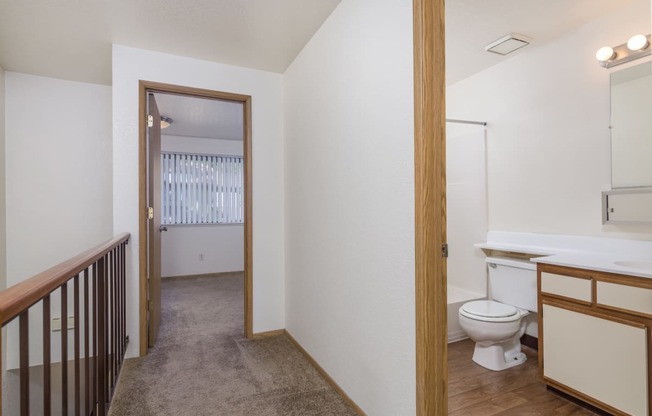 a renovated bathroom with a toilet and a sink in a room with a hall way