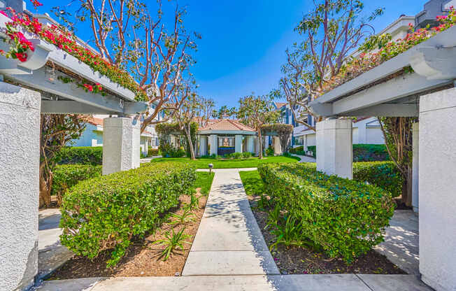 a house with a pathway and hedges in front of it