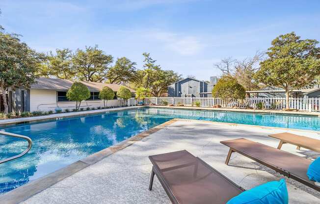 A pool with a bench and a table in front of it.