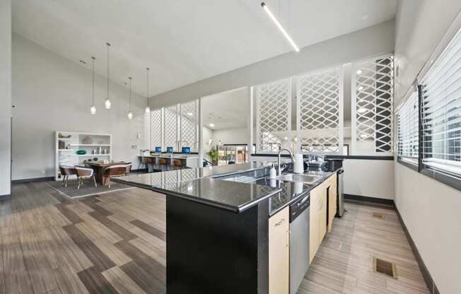 A modern kitchen with a black countertop and wooden flooring.