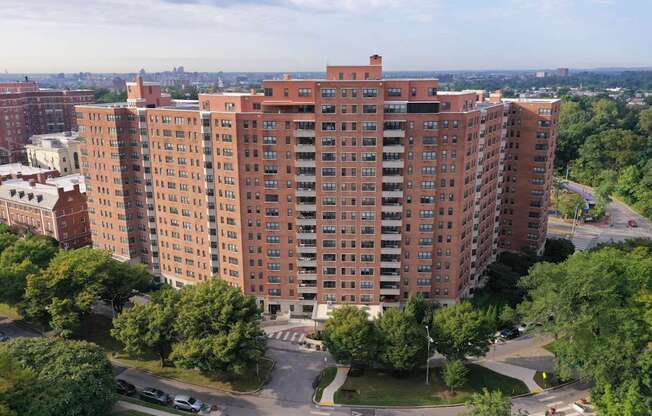 A large red brick building with a parking lot in front.