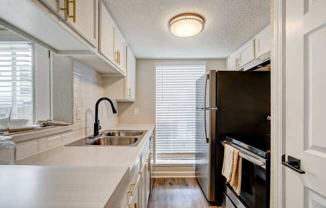 a kitchen with white cabinets and black appliances
