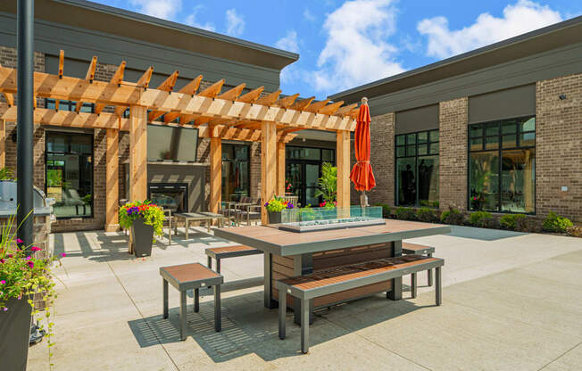 a patio with tables and benches outside of a building
