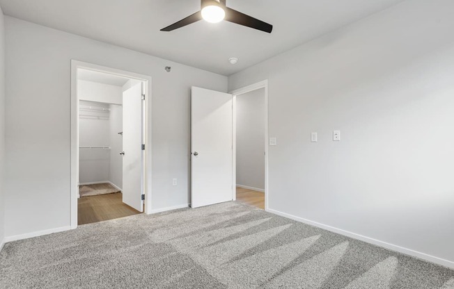 A room with a ceiling fan and a carpeted floor.