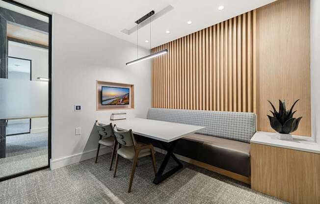 Private work suite with built-in seating, modern lighting, and digital screen for focus and productivity