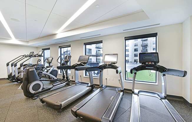 A gym with treadmills and elliptical machines.