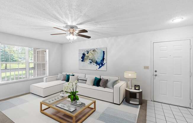 a living room with a white couch and coffee table and a ceiling fan