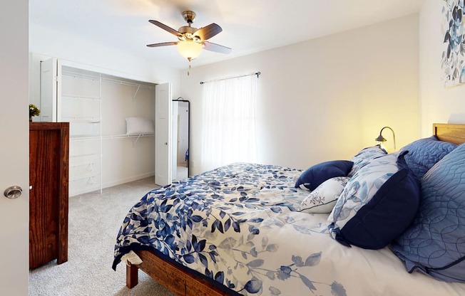 a bedroom with a large closet and a ceiling fan