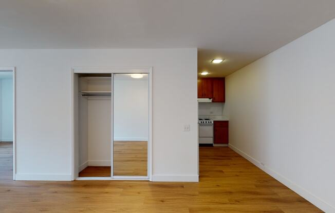 a bedroom with a medium hardwood floor and white walls