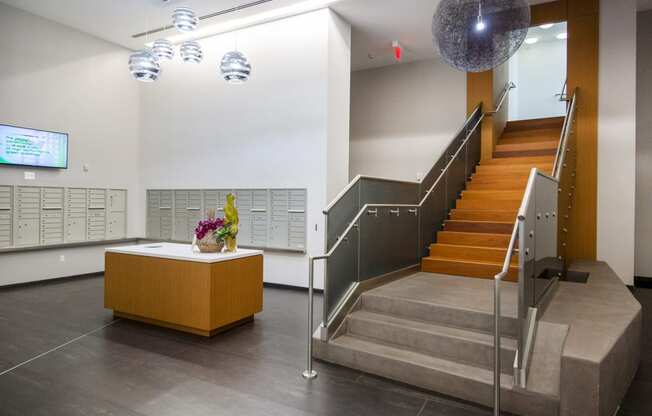 a view of the lobby of a building with stairs and a desk with a plant