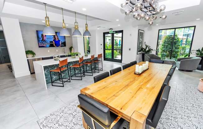 a dining room with a long wooden table and black chairs