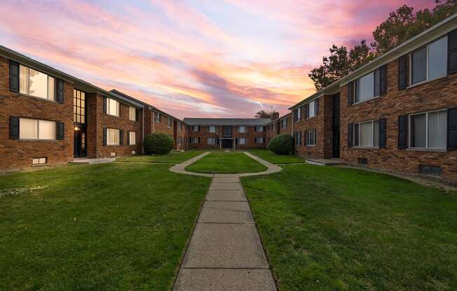 an exterior view of an apartment building with a sidewalk