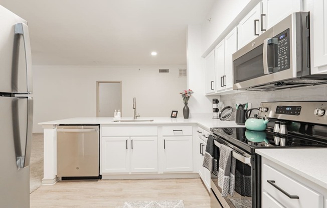a renovated kitchen with white cabinets and stainless steel appliances