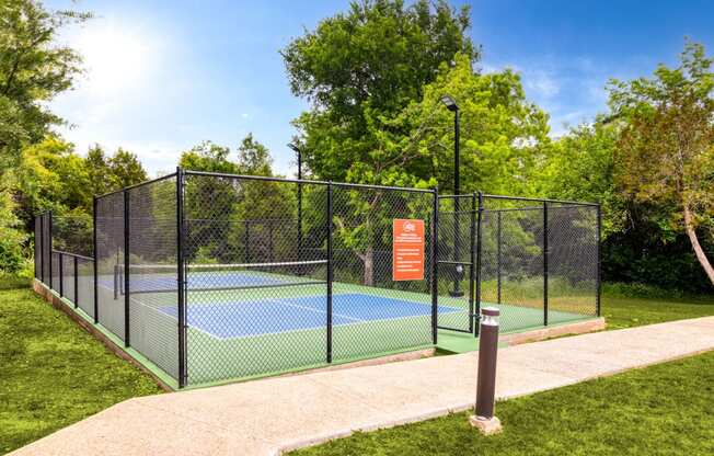 a tennis court with a fence around it on a sunny day