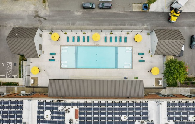 an overhead view of a building with a pool and cars parked around it