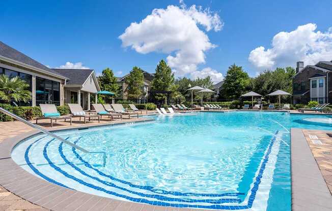A large swimming pool with a blue tiled edge and a white line in the middle.