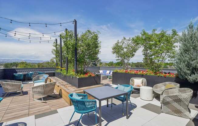 a rooftop patio with tables and chairs and trees