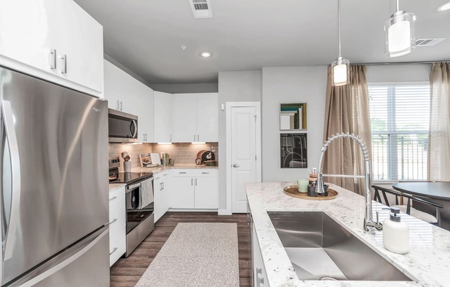 a kitchen with stainless steel appliances and white cabinets