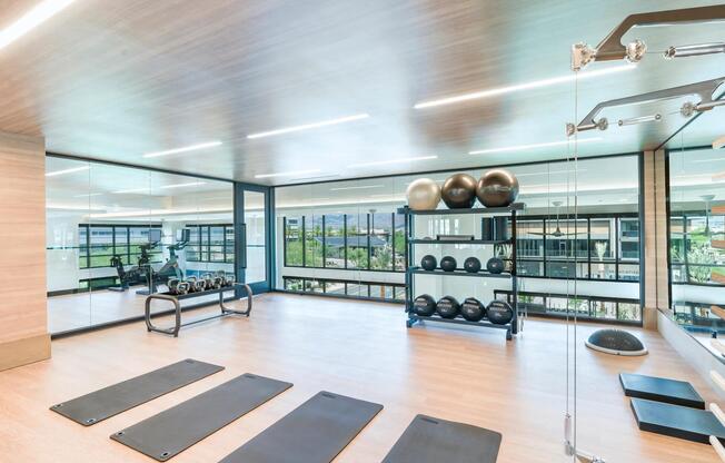 Stretch, lift, or flow in the light-filled fitness studio featuring yoga mats, weights, and floor-to-ceiling mirrors.