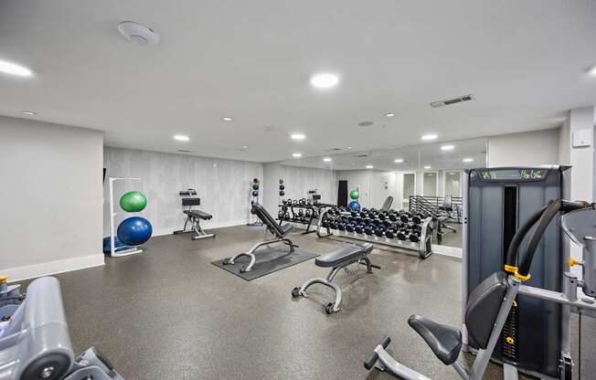 A gym with a variety of equipment including weights and exercise balls.