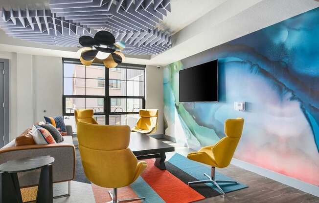 Colorful accent wall in communal space with chairs and couch