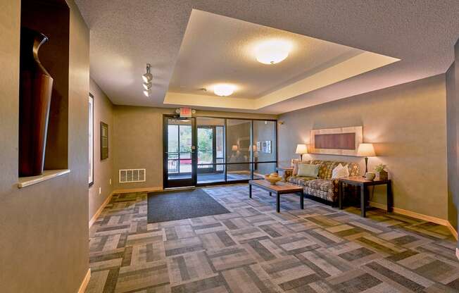 A lobby with a carpeted floor and a sofa.