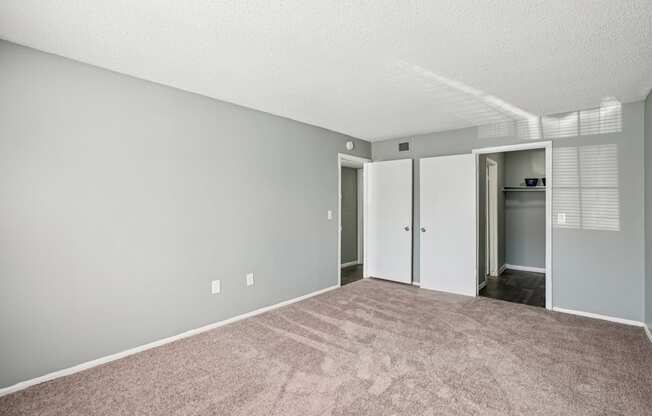 A room with a carpeted floor and a white door.