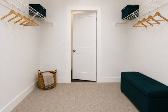 A room with a door, a bench, and a basket.