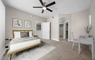 Large bedroom, carpet floors, ceiling fan with light, wall art, furnished model unit